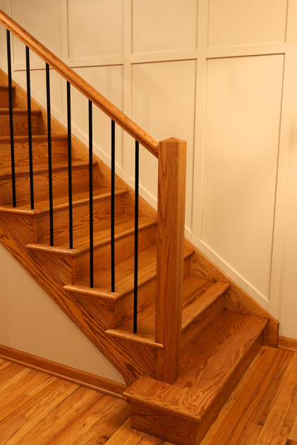 The finished renovated staircase with square newel posts and black iron balusters (1)